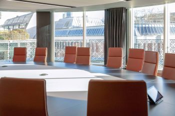 Board Room in ICG's London office, with seats around a large table and other buildings seen out of the window beyond